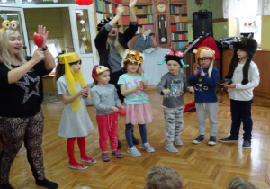 Dzieci tańczą z rekwizytami na głowie